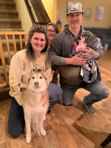 A family with their dog posing for the camera.